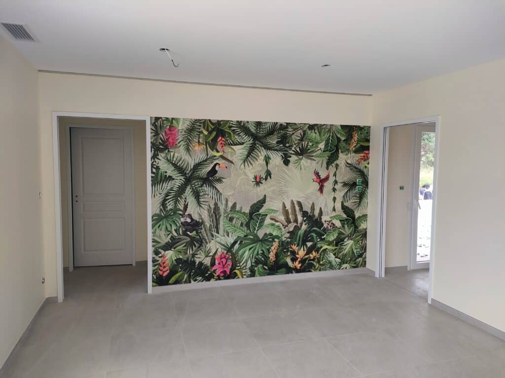 Pièce moderne murs clairs, sol carrelé gris. Mur accent tapisserie jungle tropicale avec perroquet, toucan, singe. Portes.